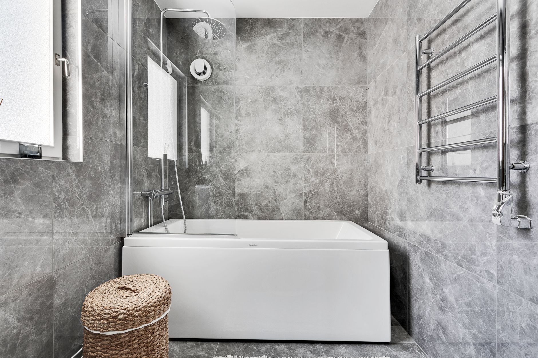 Explore a sleek and contemporary gray marble bathroom with elegant fixtures and abundant natural light in Riverside, CA